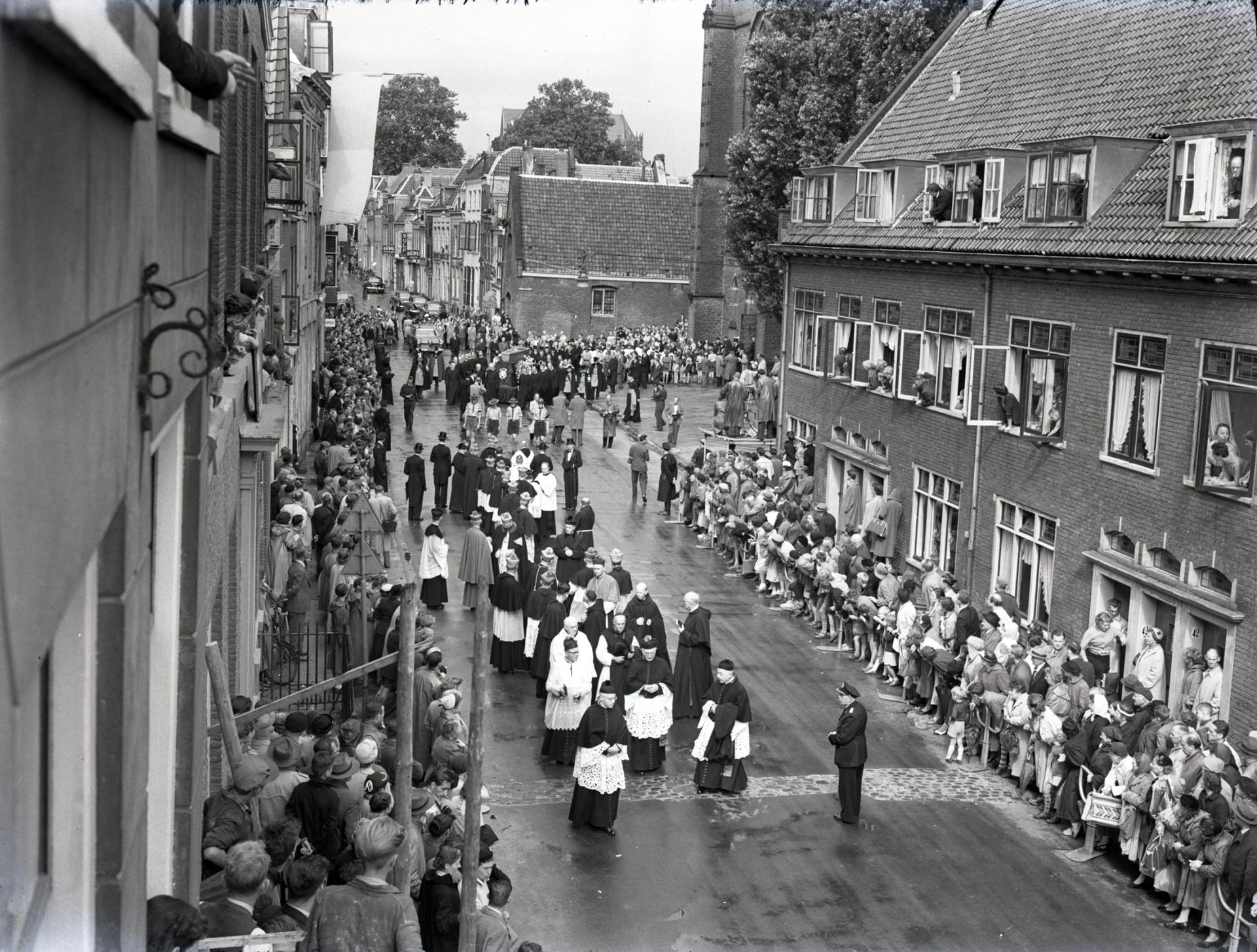 Rouwstoet in de Lange Nieuwstraat, met voorop de geestelijken, bij de begrafenis van Johannes Kardinaal de Jong in 1955. Fotograaf F.F. van de Werff.