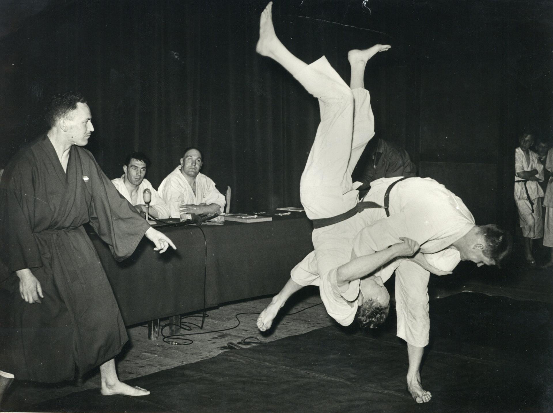 M. Oliekan versus Anton Geesink tijdens de finale van het Nederlands kampioenschap judo in Gebouw Tivoli,1951. Links Geesinks trainer Jan van der Horst.