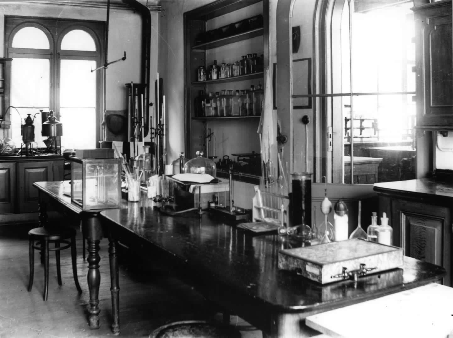 Interieur van het college- en practicumgebouw (voormalige koetshuis) in de tuin van het als Laboratorium voor Physiologische Chemie van de Universiteit ingerichte huis Maliebaan 50 te Utrecht: laboratoriumruimte. In 1992 vervaardigde reproductie van een omstreeks 1930 gemaakte foto.