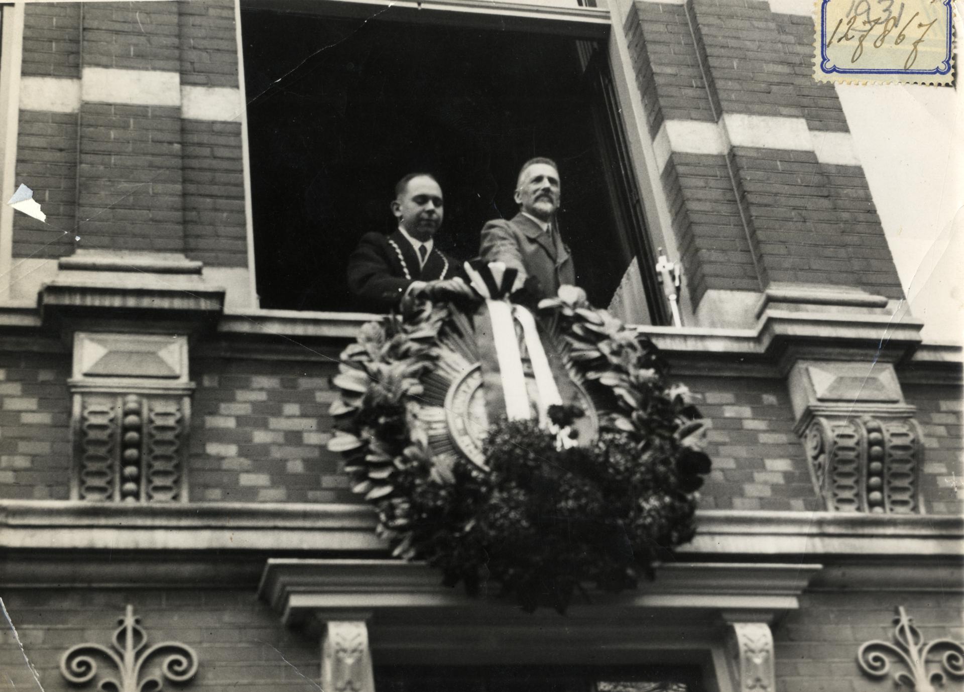 Afbeelding van dr. J.W. Wicherink UIT 1931 die een krans bevestigt aan het wapen van studentenvereniging Unitas Studiosorum Rheno-Traiectina (USR) aan de voorgevel van de sociëteit (Lucasbolwerk 8) te Utrecht, in het kader van de viering van het 4e lustrum van de vereniging.<br />
<br />
N.B. Dr. J.W. Wicherink was een van de initiatiefnemers tot de oprichting van USR. <br />
<br />
De foto bevindt zich in het archief van Unitas Studiosorum Rheno-Traiectina: fotoverzameling, toegangsnummer 780-2, inv.nr. 28, fotonr. 664.