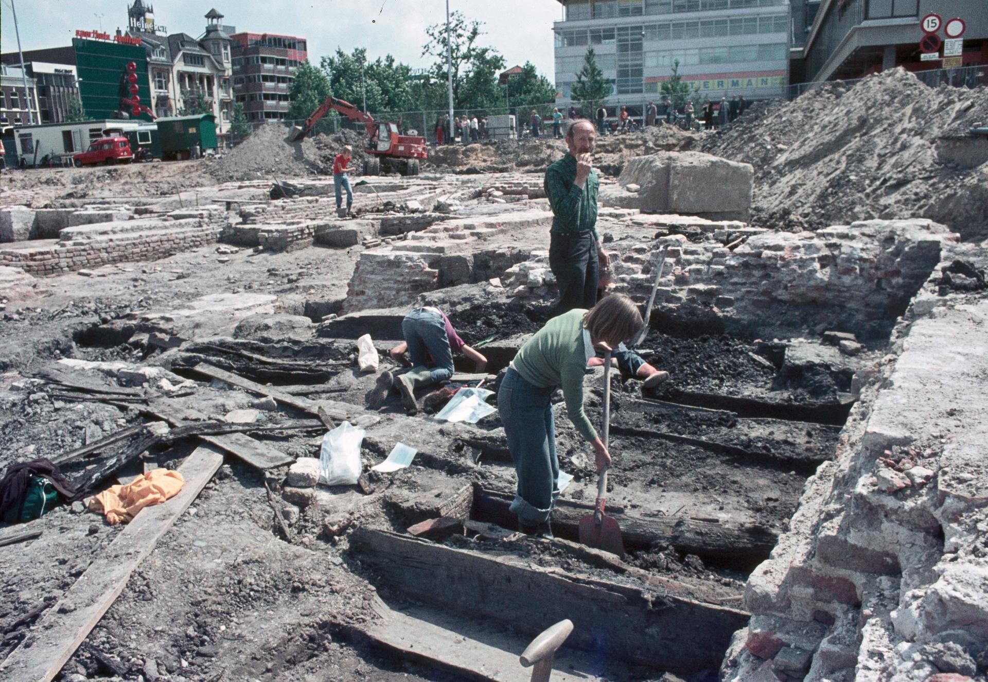 Uilenbroek, W.H.M., fotograaf/filmer (1976). Afbeelding van archeologen tijdens de opgravingen van het vroegere kasteel Vredenburg op het Vredenburg te Utrecht, met in het midden gemeentearchivaris dr. J.E.A.L. Struick.